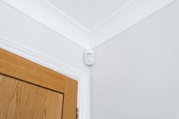 Newly installed wireless and battery operated new generation PIR alarm sensor in a downstairs room. Connected to a central alarm system which is activated on body heat.