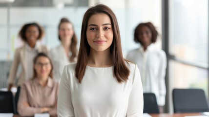 Obraz premium A confident woman stands in front of a diverse group, showcasing leadership in a modern office setting.