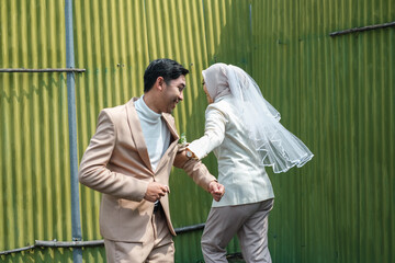 A couple on Valentine's Day holding hands while joking happily in the public area