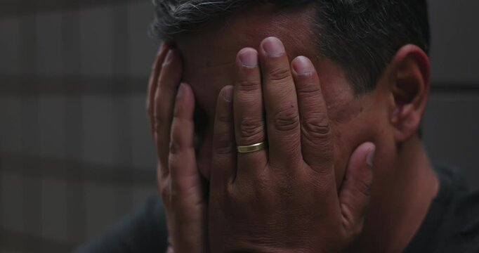 Man covering face and holding head with hands, overwhelmed by despair and emotional turmoil, conveying sadness, inner pain, mental struggle, and hopelessness during isolation
