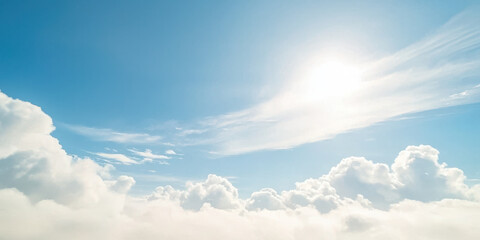Fototapeta premium Bright sun shining over fluffy white clouds in clear blue sky