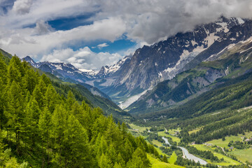Obraz premium Val Ferret mountain landscape in the Alps. Beautiful alpine scenery of the high mountain summits and green valley in summer under blue sky at sunny weather om Tour du Montblanc