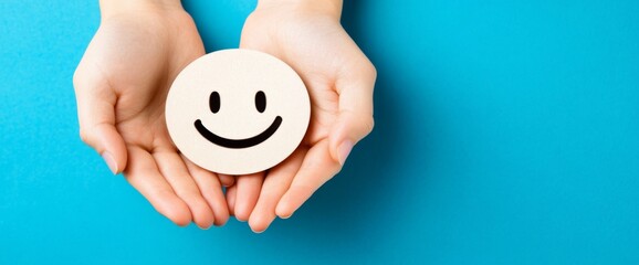 Hands cradling a joyful face symbol against a serene blue backdrop, embodying positivity and the essence of a cheerful life, ideal for banner design