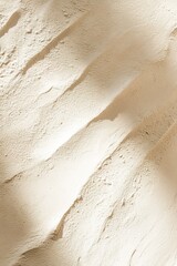 Soft clay texture in warm beige tones with natural light reflections creating a serene and spacious backdrop for design elements