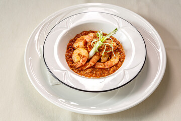 A plate of shrimp and rice with a garnish of green vegetables