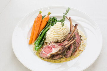 A plate of lamb chops, potatoes, and carrots