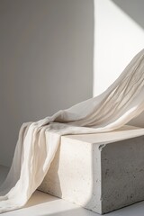 Minimalist Nordic-style stone podium adorned with flowing linen drape against a soft, muted backdrop showcasing natural textures