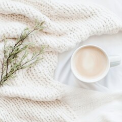 Cozy morning scene with a cup of coffee, soft blanket, and greenery on a light background perfect for relaxation and comfort themes