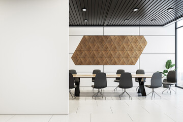 Spacious modern conference room with black chairs, wooden geometric wall decor on white walls, and natural light. Concept of office interior. 3D Rendering.