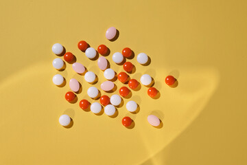 Colorful pills on a yellow background.