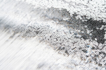 Abstract festive fabric texture with silver sequins.
