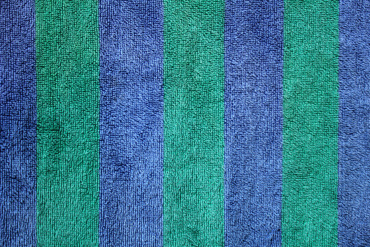 The green and blue towel cloth background is separated by parallel lines. Patterned towel fabric