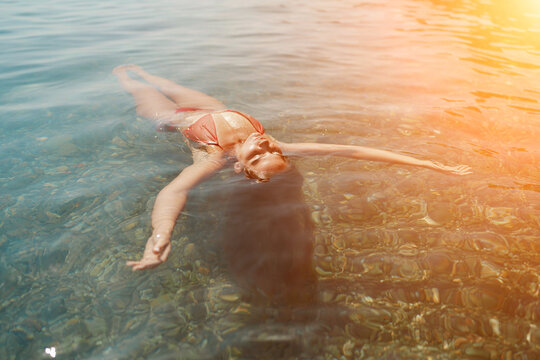 Happy woman sea relaxing floating in transparent sea water on summer holiday. Travel leisure recreation lifestyle, female in nature.