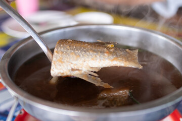 Sweet and sour grey mullet fish soup with ginger in hot pot.