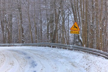 Animals crossing road sign on snowy, winter road