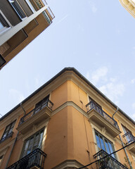 Bâtiments typiques de Valence capturés en contre-plongée, avec le ciel clair en arrière-plan. Une perspective mettant en valeur l'architecture locale et son élégance.