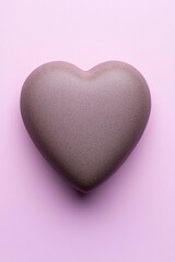 Obraz premium A beautifully shaped heart stone resting on a soft pink background, symbolizing love and affection.