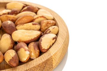 Brazil nuts without shells on a wooden plate, close-up, isolated on a white background.