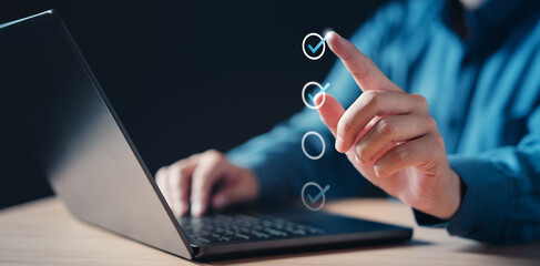 checklist, checkbox, document, plan, tick, choose, check, choice, touching, mark. A person is using a laptop with a check mark on it. The person is touching the check mark with their finger.