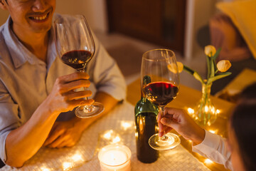 couple, valentine, celebrate, romantic, anniversary, affection, loving, affectionate, party, wine. A man and a woman are sitting with wine glasses in front of them.