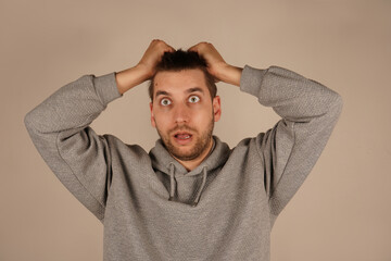 His face conveys frustration or anxiety. The image highlights his reaction to intense thoughts or stress. A man with his hands on his hair, a common gesture, is experiencing mental overload.