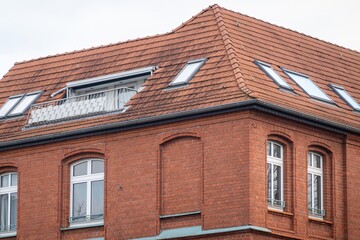 Red brick building with balcony and skylights showing urban living