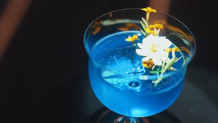 Closeup beautiful mixed vodka blue hawaii cocktail decorated with flower at luxurious counter bar perfect for advertisement in vibrant color presentation highlight atmosphere at nightclub. Vinosity.