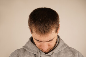 Fototapeta premium The texture of his hair is clear, and the shape of his head is emphasized. A close-up of a man's head with dark hair. This perspective gives a mysterious and contemplative feel.