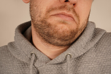 Obraz premium Perfect for themes of grooming and casual style. A detailed close-up of a man's chin with subtle stubble, showcasing masculine appeal. The unshaven look exudes effortless charm and simplicity.