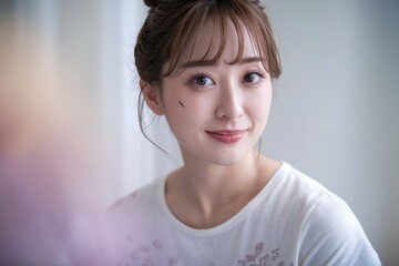 Fototapeta premium A young woman with a subtle smile, her face partially visible against a blurred background.