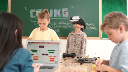 Energetic child wearing Vr headset while enter virtual world at classroom. Student programing...