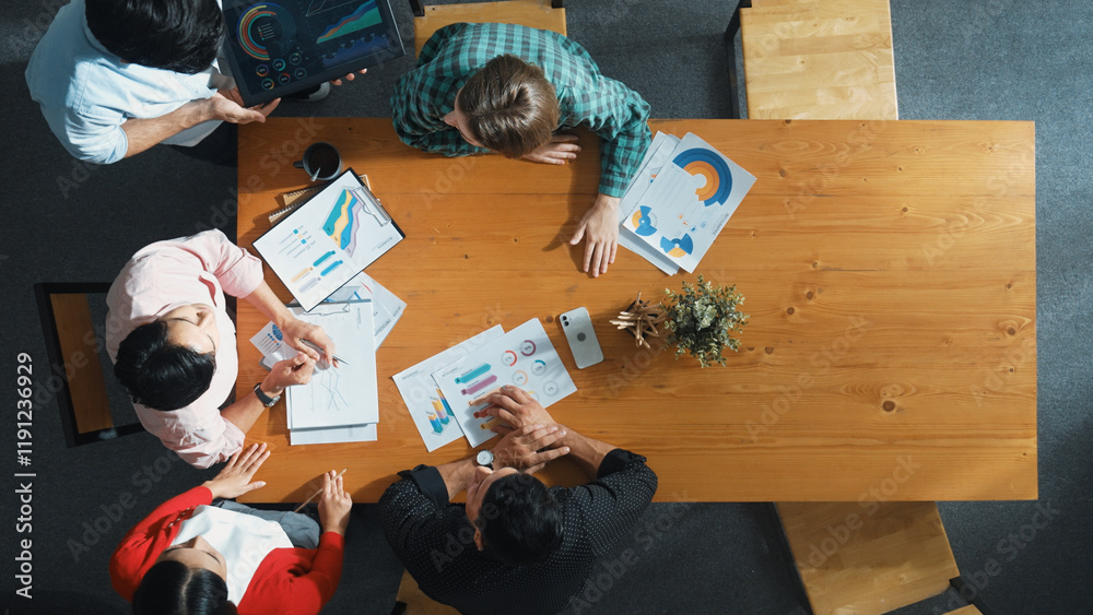 Wall mural top view of business man using tablet display increasing graph while diverse marketing people sharin