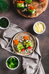 Christmas trees made of cucumber and cherry tomatoes on skewers on a plate top and vertical view