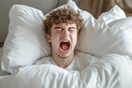 Teenager shouting loudly while lying in bed, experiencing a nightmare or sleep paralysis