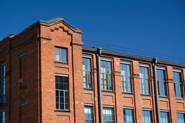 red brick building with large windows and blue sky