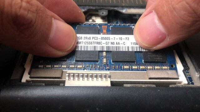 Professional technician installs laptop ram memory. Repairman fixes and maintains computers. Memory upgrade. Desktop computer hardware