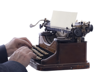 Hands typing on a vintage typewriter with a blank sheet of paper ready for words in a cozy workspace