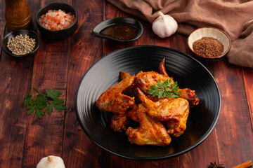 Air Fryer Chicken whole wings (Chicken 3 Joint Wing) with salt in black plate.Crispy and Healthy cooking.