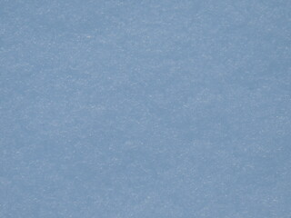pale blue background of natural snow crust texture with white glitters and snowflake flakes, bluish simple empty backdrop with soft grainy texture and empty copy space