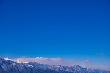 青空と冠雪した山岳風景