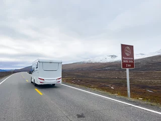 Fototapeten Exploring the nordic landscapes: a white camper van on a scenic road in norway, heading towards the arctic circle for an adventurous journey © Alberto Gonzalez 