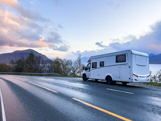 Fototapeta premium A motorhome parked by the road in the autumn landscape of the Lyngen Alps, Northern Norway, with mountains.