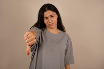 The scene evokes a strong negative reaction. The woman holds her hand with her thumbs down, clearly...