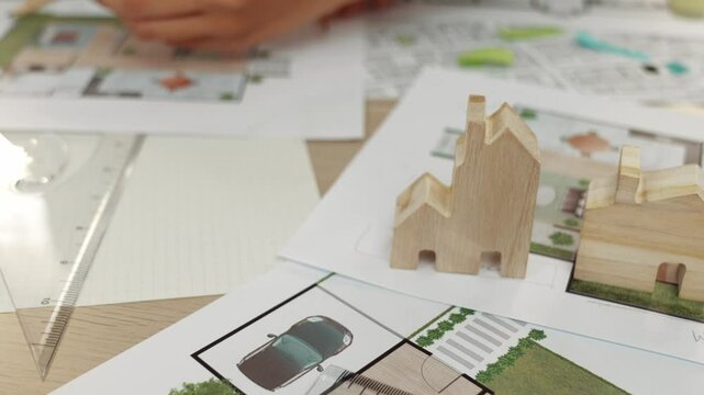 Smart architect and safety engineer discussion about building blueprint on table with architectural document, measurement tools and wooden block scatter around at modern office. Closeup. Delineation.