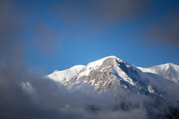 Winter in the Romanian mountains. Beautiful view through the clouds to Bucegi Mountains, next to Busteni, Azuga, Sinaia and Predeal mountain ski resorts. Travel and hike to Romania.