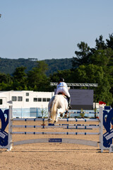 woman jumping with her horse in a championship