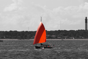 red and black study of a sailboat sailing on the Arcachon basin, in the southwest of France in the Aquitaine region