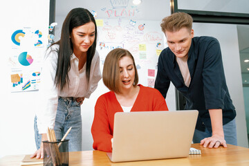 Professional business team working together by using laptop in start up project at meeting in front of glass board with mind map while colleague brainstorm and discuss about strategy. Immaculate.