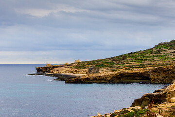 Fototapeta premium Scenic Coastal Cliff side Landscape Overlooking Calm Ocean Waters Under Cloudy Skies