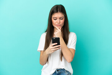 Fototapeta premium Young caucasian woman isolated on blue background thinking and sending a message